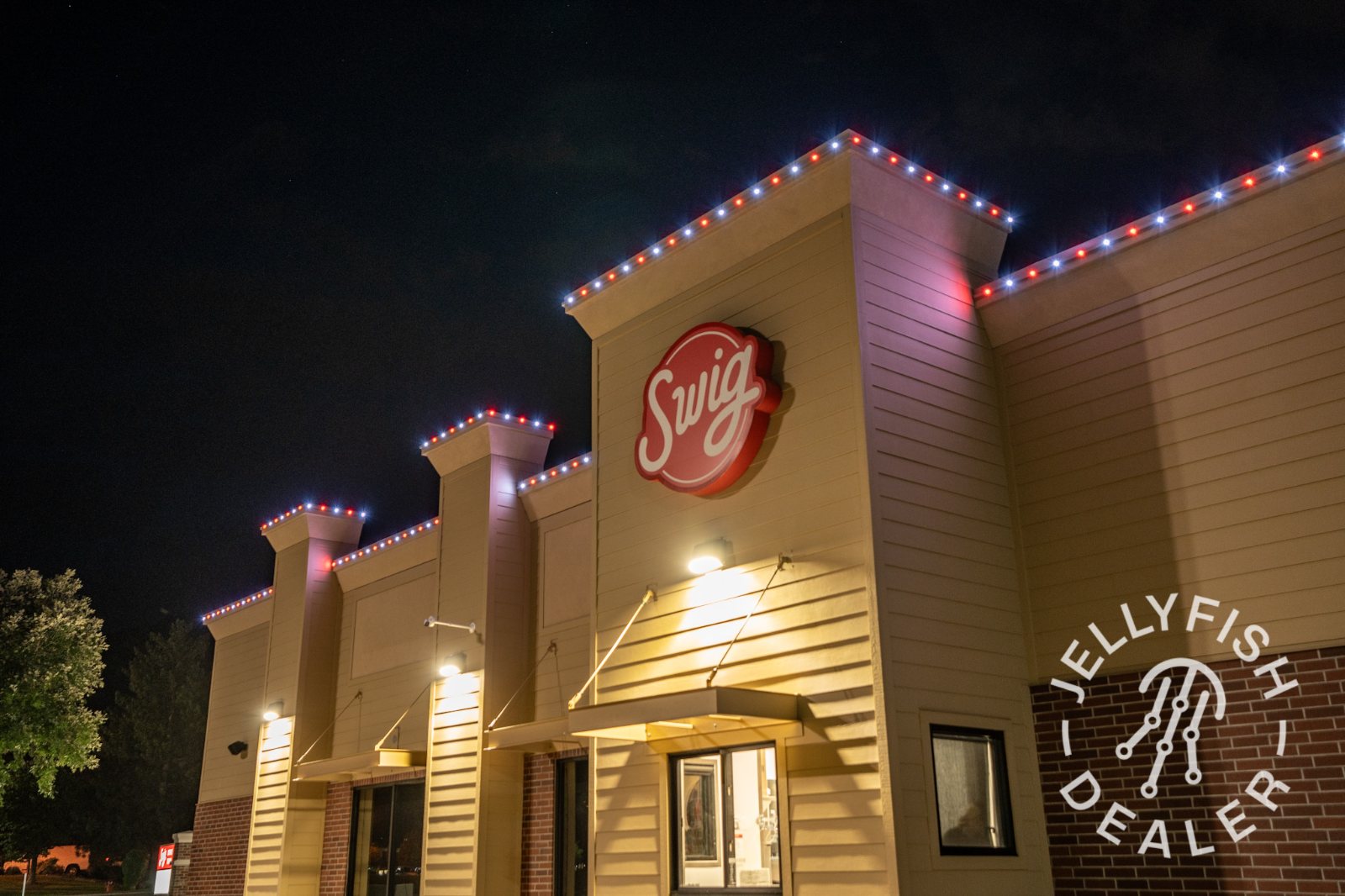 A drive-thru restaurant lit in red, white and blue