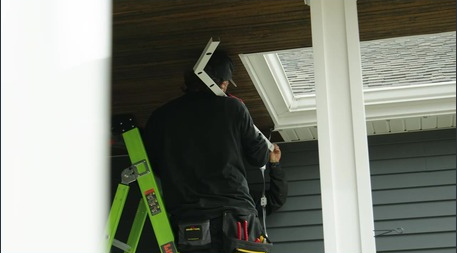 Color-matched track going up under an eave by day